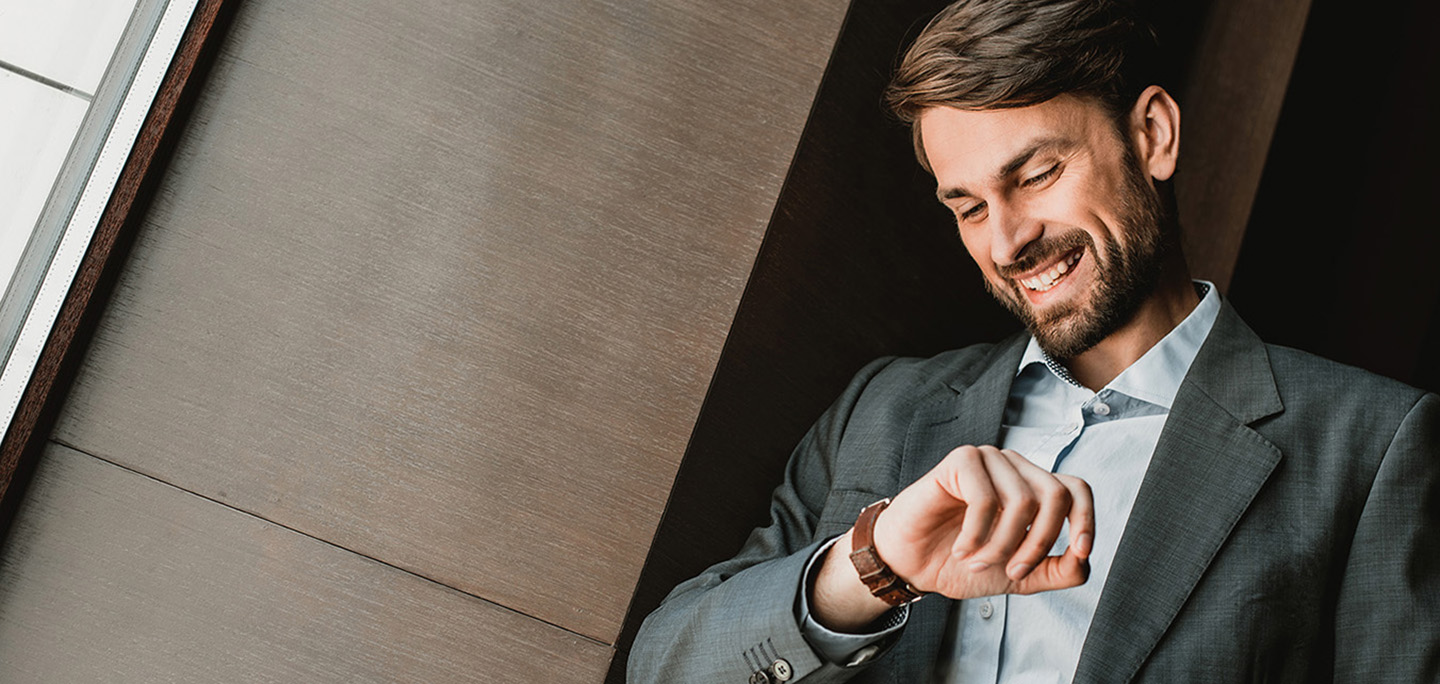 Man looking at his watch and smiling.